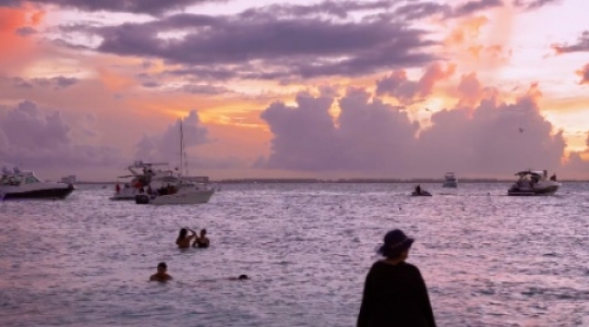 Isla Muieres people and boats at beach with sunset static shot - 2