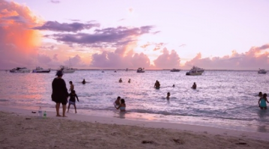 Isla Mujeres people and boats at beach with sunset static shot -1 slo mo 