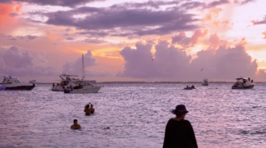 Isla Mujeres people and boats at beach with sunset static shot -2 slo mo 