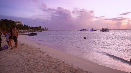 Isla Mujeres people and boats at beach with sunset static shot -3 slo mo 